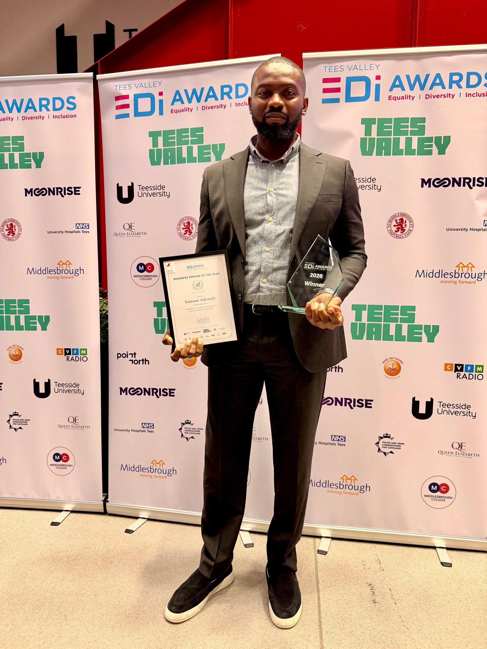 Samson Adewole holding his Business Person of the Year certificate and trophy